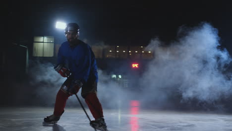 Professioneller-Eishockeyspieler-Mit-Schläger-Beschleunigt-Auf-Dem-Eis-Und-Stoppt-Abrupt-Vor-Der-Kamera-Und-Schaut-Direkt-In-Die-Kamera